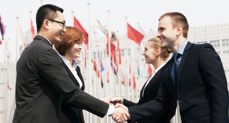 a Chinese businessman and a Chinese female business women shaking hands with a caucasian female business woman and a caucasian business man 