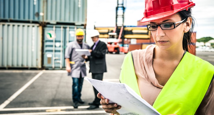 Workers at a dock calculating import fees and looking at anti dumping duty paperwork